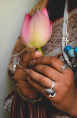 Close-up shot of a woman with sari and holding lotus flower