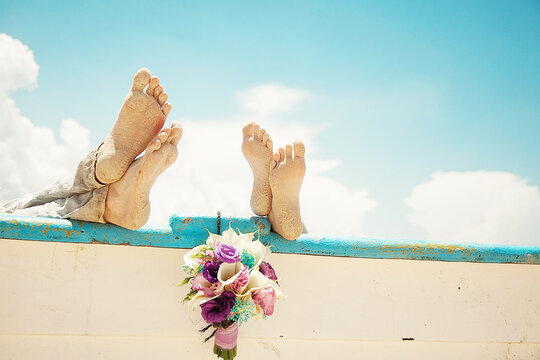 Couples' feet on wall and bouquet of roses hung between