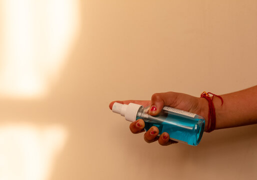 Cropped hand holding sanitizing bottle