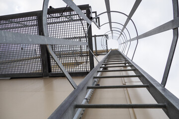 View of a metal ladder with a rest near the building.