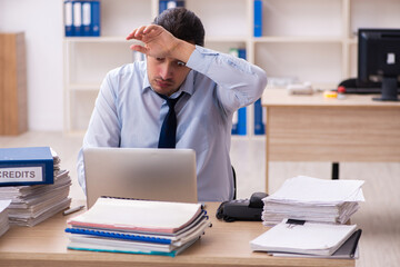 Fototapeta premium Young male employee and too much work in the office