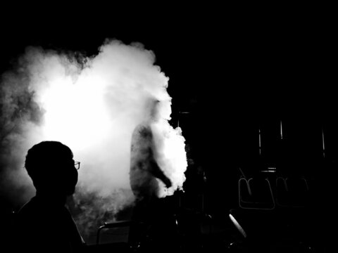 Grayscale photo of two men surrounded by smoke