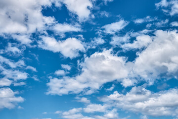 Fluffy clouds against the bright blue sky. Nature background. Copy space