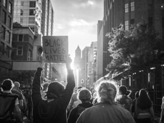 Man holding banner with " Black Lives Matter " written on it at a protest