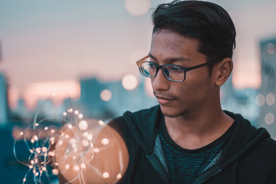 Man holding string light to his face