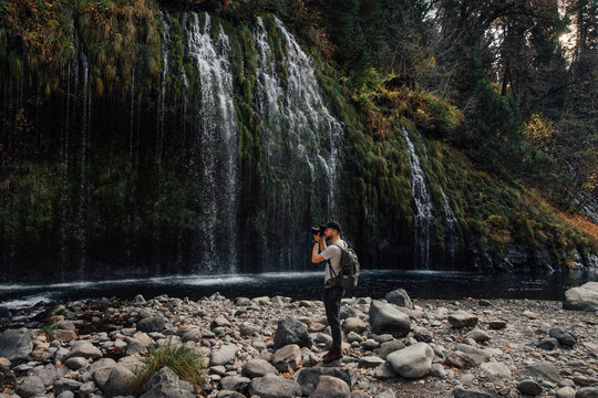 Man taking a photo of waterfall with camera