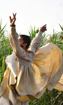 Man wearing off-white dress dancing outdoor