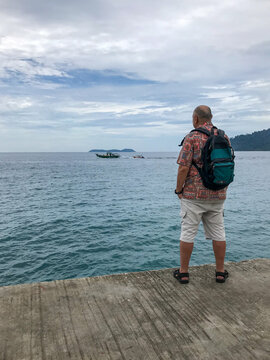 Man with a backpack standing on dock