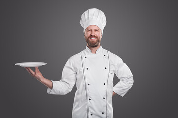Cheerful chef in uniform with plate