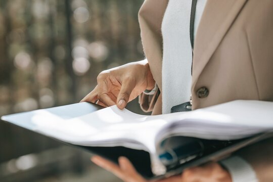 Person in blazer holding a paper document