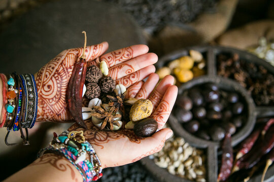 Persons hands with henna tattoo holding dried seeds