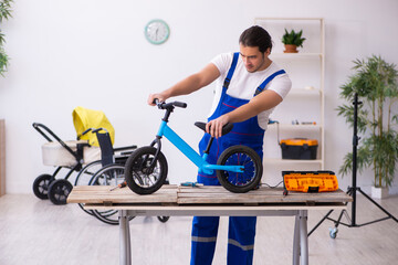 Fototapeta na wymiar Young male repairer repairing bike indoors