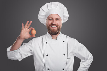 Happy male cook showing egg