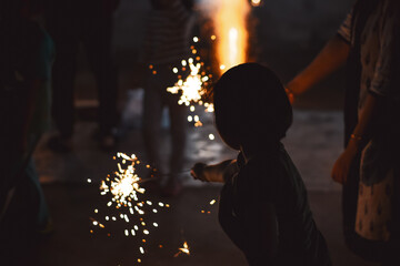 Silhouette of people holding sparkling candles during nighttime