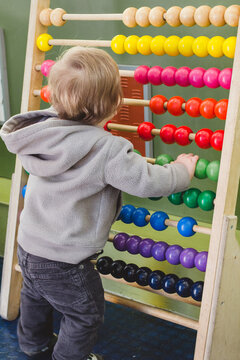 Toddler playing with old manual computing toy