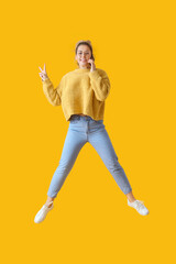 Fototapeta na wymiar Jumping young woman with mobile phone on color background
