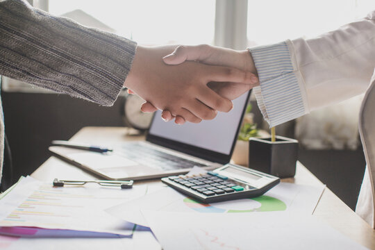 Two people handshaking in an office