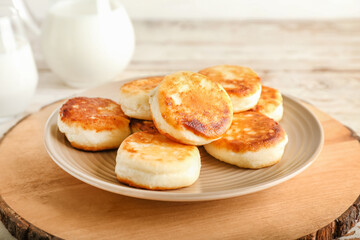 Plate with tasty cottage cheese pancakes on table