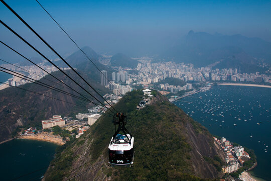 White and black cable car over green mountain in Rio de Janeiro, Brazil
