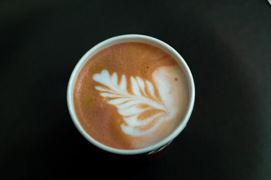 white ceramic coffee mug on black surface with latte art