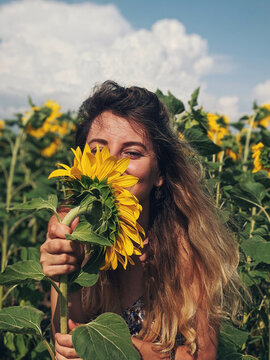 Woman hiding her face with sunflower