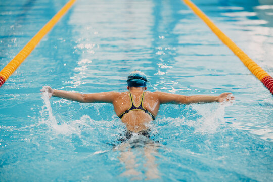 Woman in bathing suit swimming in pool