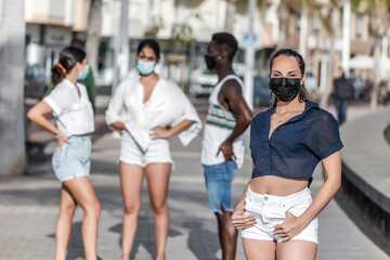 Woman in facemask posing in front of her friends