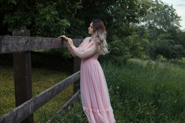 Woman in pink dress standing on green grass field