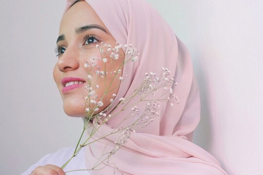 Woman in pink hijab holding gypsophila