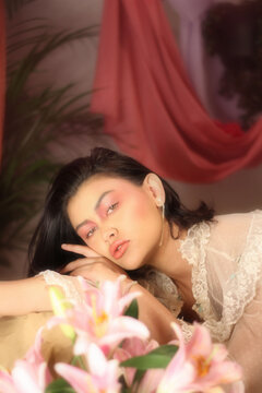 Woman lying beside flower bouquet indoor
