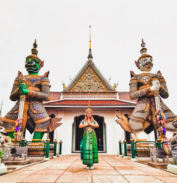 Woman standing beside a Buddhist Temple