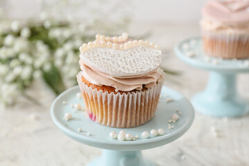 Dessert stand with tasty wedding cupcake on table