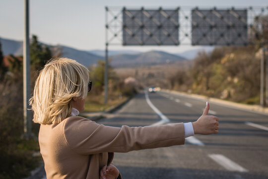 Woman stopping a car on the highway