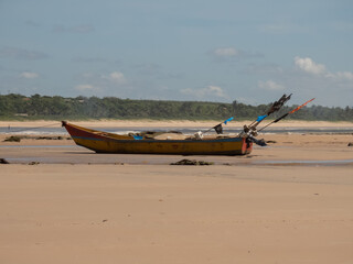 Barco de pesca ancorado na areia da praia.