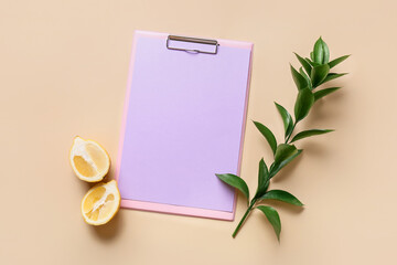 Clipboard with blank sheet of paper, lemon and plant branch on color background