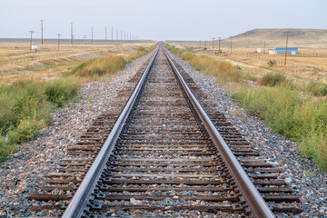 railroad tracks in a prairie of northern Colorado, late summer scenery with smoke and haze from distant wildfires - travel and transport concept