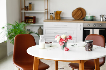 Dining table with cornflakes and vase in kitchen