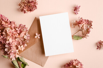 Wedding invitation card mockup with envelope and pink hydrangea flowers decorations.