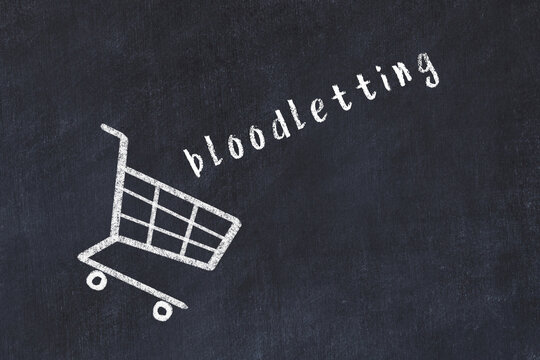 Chalk drawing of shopping cart and word bloodletting on black chalboard. Concept of globalization and mass consuming
