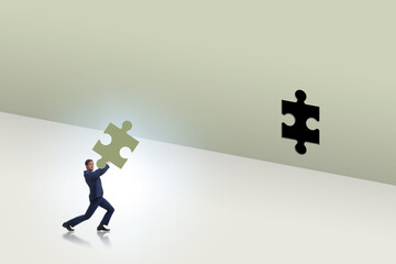 Businessman putting missing jigsaw puzzle piece