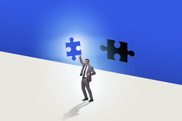 Businessman putting missing jigsaw puzzle piece