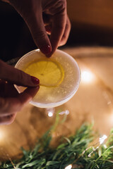 hands bartender placing lemon slice on egg white cocktail fizz sour