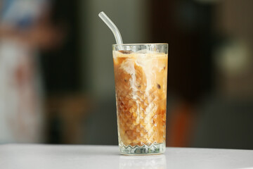 Glass of tasty ice coffee on table