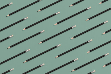 Pattern composition of black pencils on a green background. Top view. Flat lay. Back to school concept.