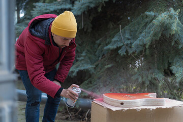 man applies a spray can on a homemade product. Selective focus background