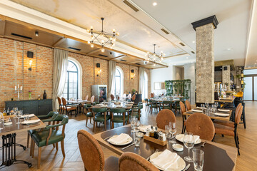 Interior of an empty large hotel restaurant with brick walls