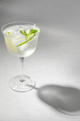 Glass of cold gin and tonic on white background