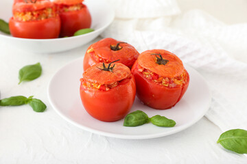 Plates with tasty stuffed tomatoes on light background