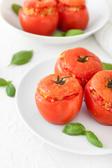 Plates with tasty stuffed tomatoes on light background, closeup