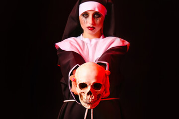 Woman dressed for Halloween as nun with skull on dark background